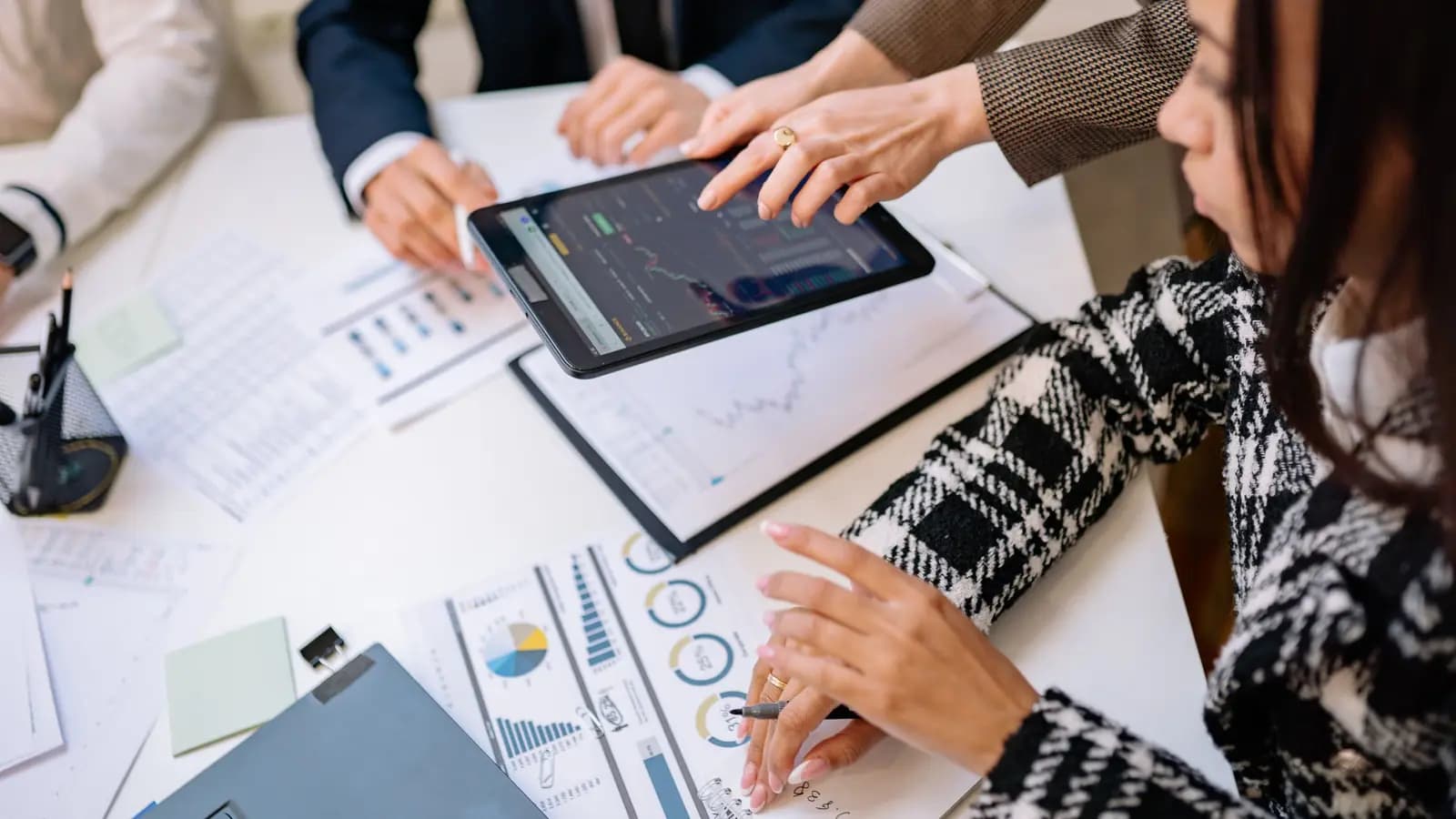Printed performance charts and a tablet on a desk during a review